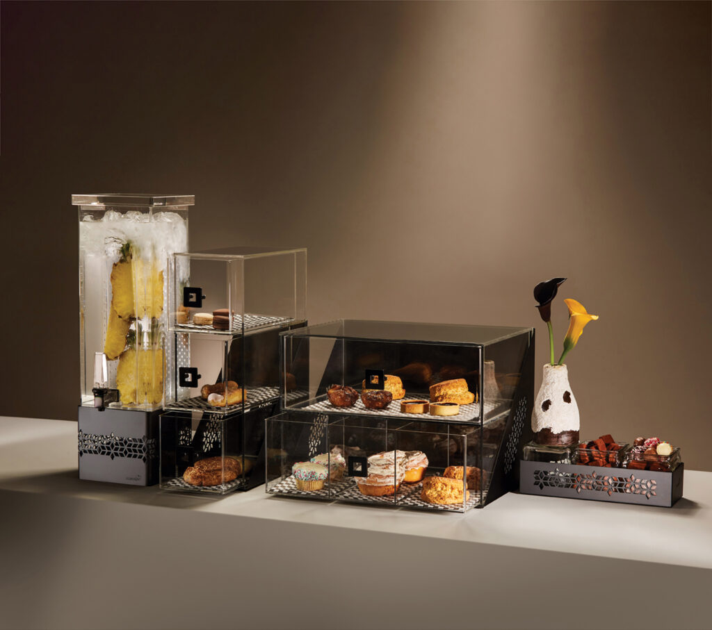 Clean buffet setup with Rosseto beverage dispenser, risers and bakery case