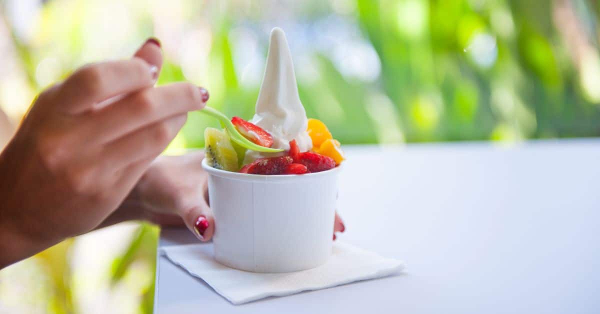 Women hand eating a yummy frozen yogurt