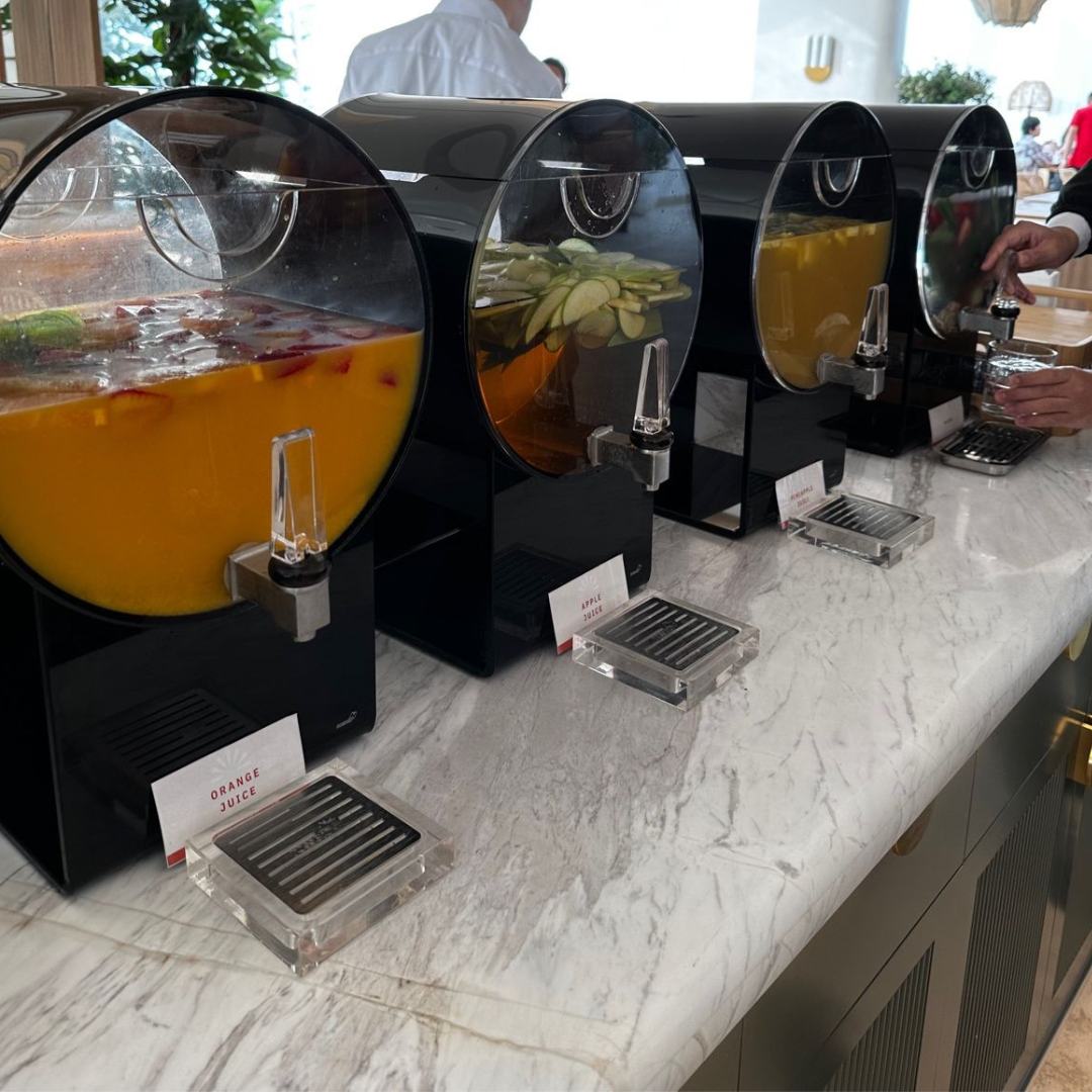 Row of Rosseto beverage dispensers with infusers on a marble counter