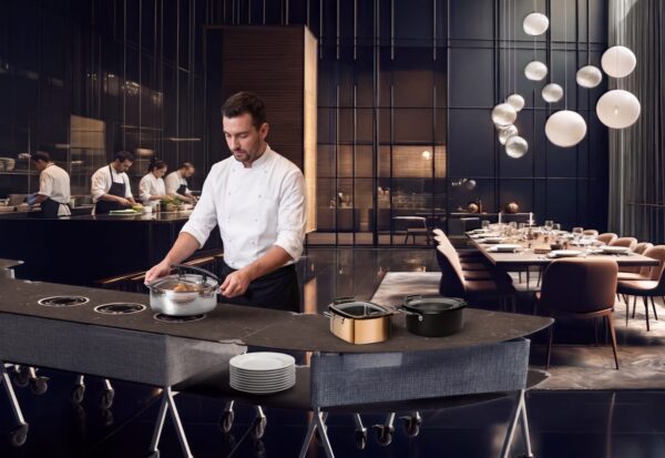 Chef serving from a curved Modulite induction table with built-in induction zones
